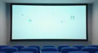 A bright empty cinema with blue seats and a glowing pale turquoise screen from which small glass cubes float into the room