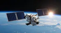 A small satellite with two dark-blue solar panel wings in low Earth orbit above the blue curve of the Earth, with the sun rising at the horizon